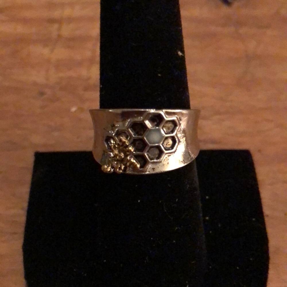 sterling silver ring has a honeybee Sitting on a honeycomb with Moonstone as wax
